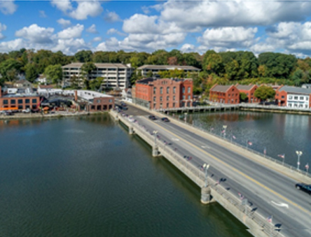 A bridge over water with buildings in the background.