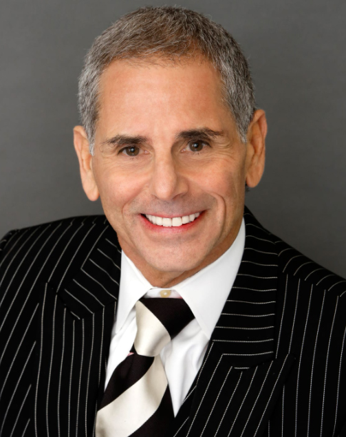 Man in striped suit smiling at camera.